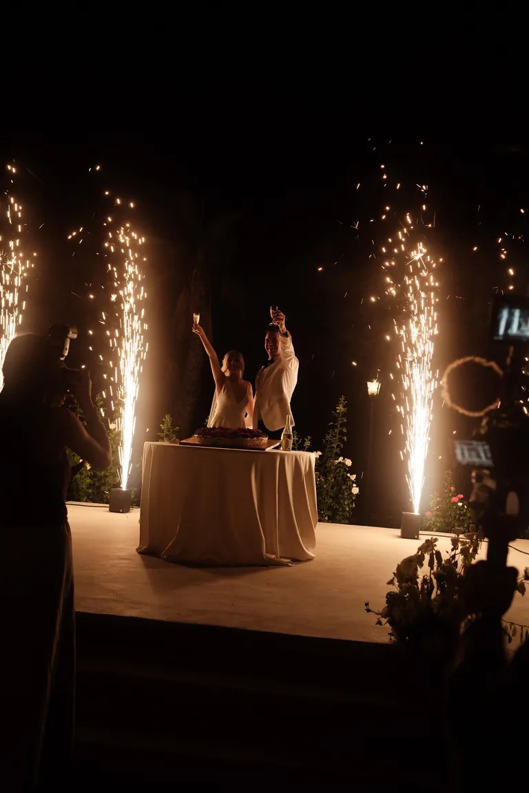 Couple cutting the cake with cold fireworks