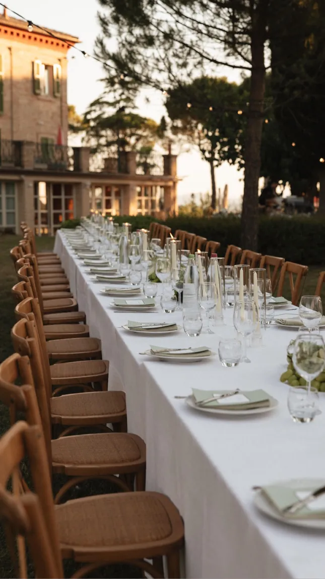 Long dinner table with wooden chairs beside the villa