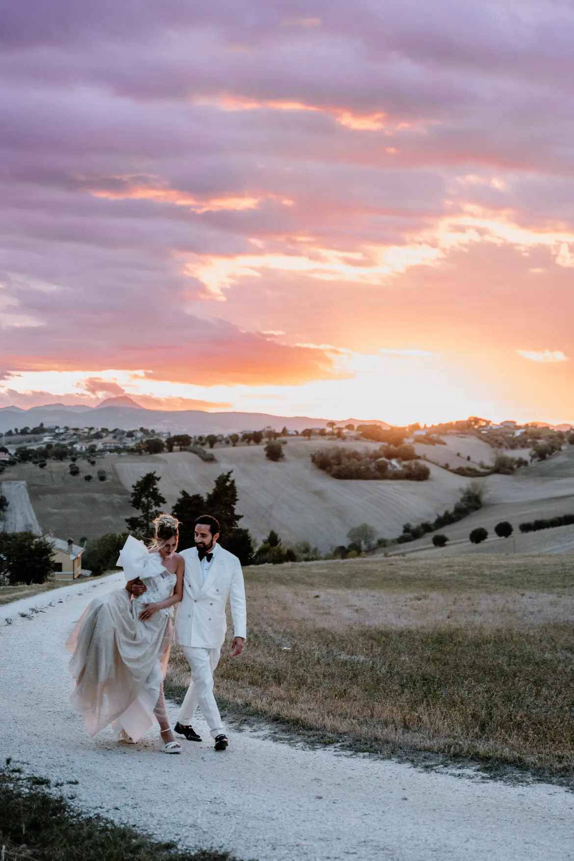 Couple walking on a country road at sunset