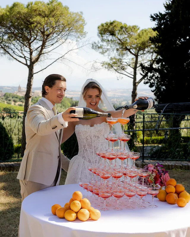 Couple pouring a prosecco tower decorated with lemons