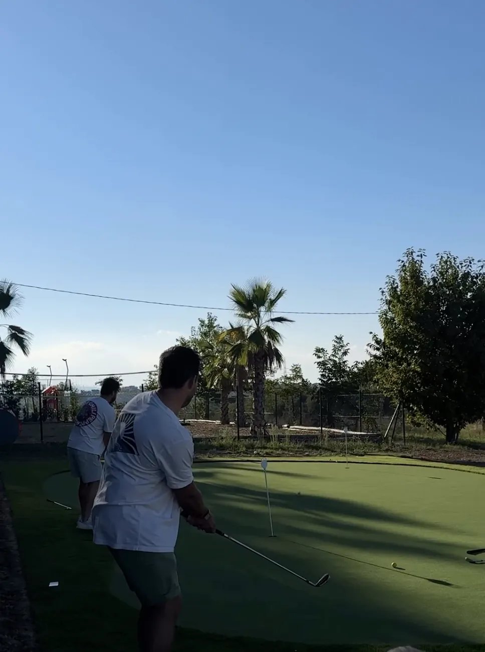 Gäste beim Chippen auf dem neuen Putting Green im Maniero, dahinter Palmen