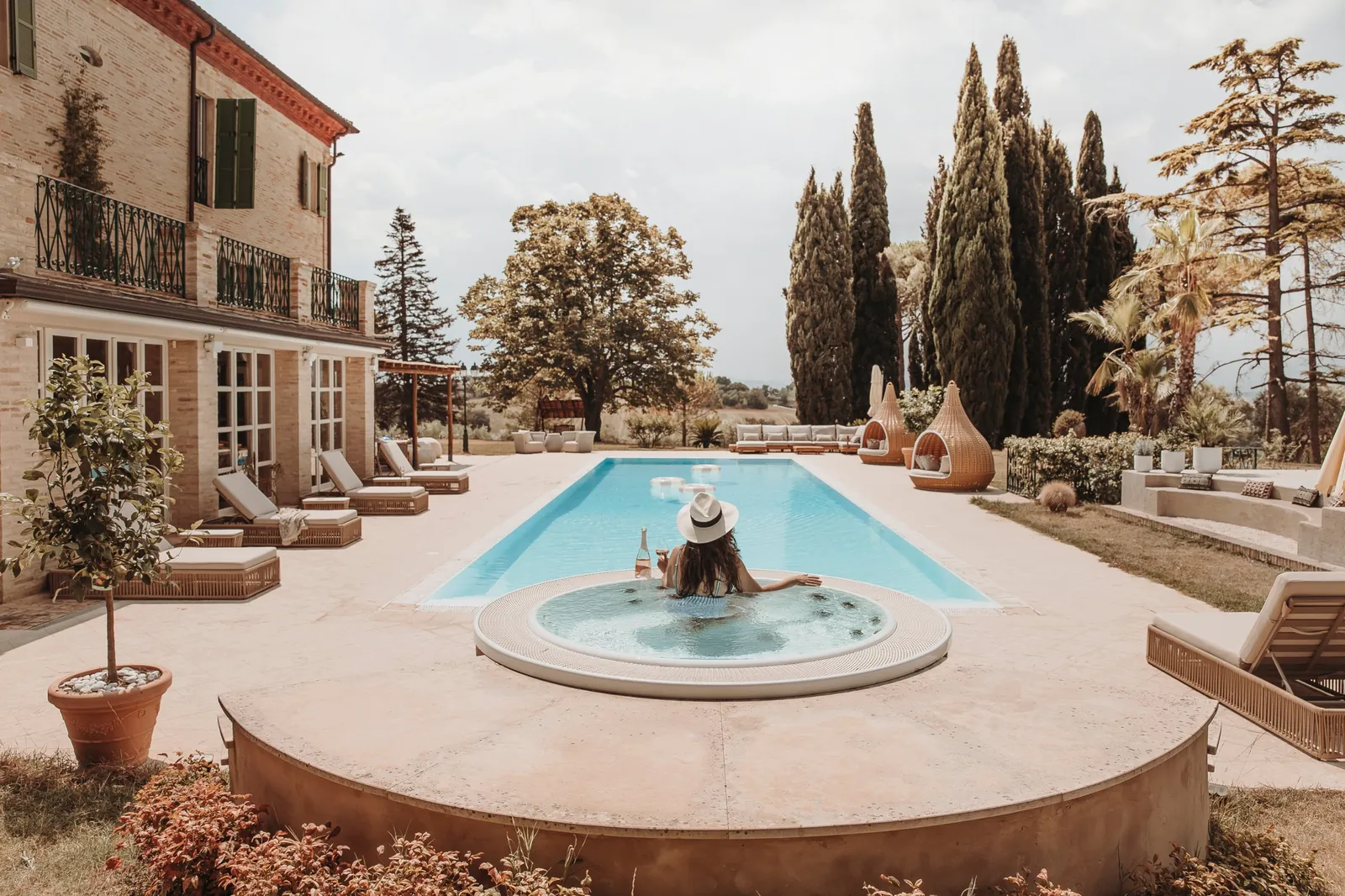 Guest relaxing in the jacuzzi at the end of the pool with a glass of rosé